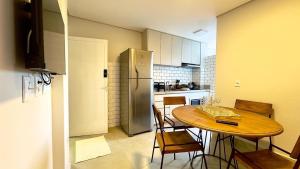 a kitchen with a wooden table and a refrigerator at Essenza Living in Formosa
