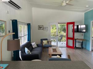 a living room with a couch and a red door at Kooyong Apartments, Arcadia in Arcadia