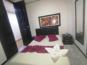a bedroom with a large bed with a flower on it at Hospedaje Luna Dorada in Manizales