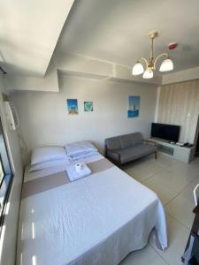 a bedroom with a white bed and a couch at Carlota247 in Cebu City