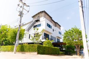 a white building with a staircase on the side of it at The Modeva Hotel in Kanchanaburi City