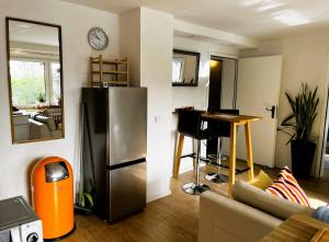 a kitchen with a refrigerator and a table in a room at Garden apartment in Ettlingen