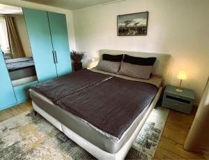 a bedroom with a large bed with a blue cabinet at Garden apartment in Ettlingen