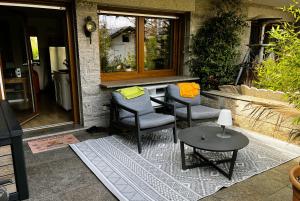 a patio with three chairs and a table and a window at Garden apartment in Ettlingen