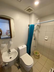a bathroom with a toilet and a sink and a shower at Carlota247 in Cebu City