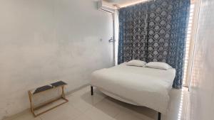 a small bedroom with a bed and a window at Just Inn in Semarang