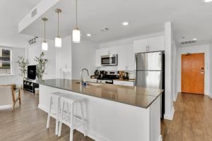 a kitchen with a counter and a refrigerator at HEB 104 Spacious Condo Downtown Fort Worth, Free Parking, Gym in Fort Worth
