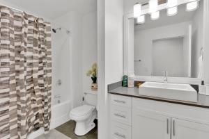 a bathroom with a sink and a toilet and a mirror at HEB 104 Spacious Condo Downtown Fort Worth, Free Parking, Gym in Fort Worth +18 photos