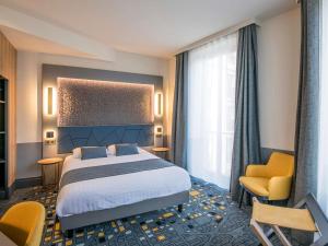 a hotel room with a bed and a chair at Hôtel Mercure Rodez Cathédrale in Rodez +53 photos