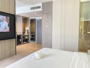 a room with a bed with a hat on it at Swiss-Belexpress Jemursari in Surabaya