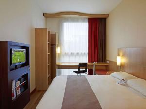 a hotel room with a bed and a television at ibis Warszawa West Station in Warsaw