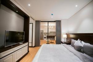 a bedroom with a large bed and a flat screen tv at Hong Gia Tue Apartment in Hanoi