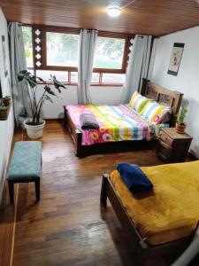 a bedroom with two beds and a window at Hostal Casalé Usaquén Embajada de Mexico in Bogotá