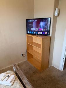 a flat screen tv sitting on top of a wooden entertainment center at Goodyear Cul-de-sac Room 6 in Goodyear