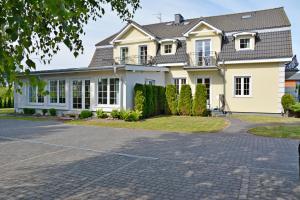 a large white house with a driveway at Villa Antoja in Grzybowo
