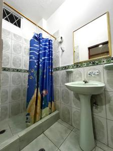 a bathroom with a sink and a shower curtain at Hostal Amazónico Bello Amanecer in Nueva Loja +17 photos