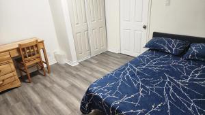 a bedroom with a blue bed and a wooden floor at Guest suite with great comfort in Brampton