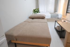 a small bedroom with a bed and a desk at Park building Tenmonkan 1 in Kagoshima