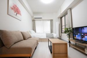 a living room with a couch and a television at Park building Tenmonkan 1 in Kagoshima