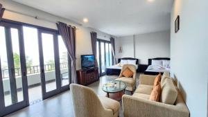 a living room with chairs and a tv and a balcony at ZEN Resort - Villa beach- Garden in Xóm Tram