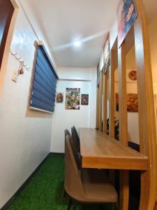 a dining room with a wooden table and chairs at Balay Madayaw in Davao City +3 photos