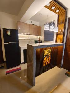 a kitchen with a black refrigerator and wooden cabinets at Balay Madayaw in Davao City