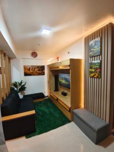 a living room with a couch and a television at Balay Madayaw in Davao City