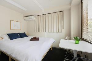 a bedroom with a large white bed and a desk at メーイン北 in Tokyo +64 photos