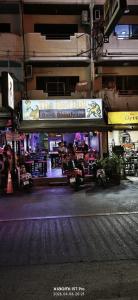 a sign for a restaurant on the side of a street at Redbull guest house in Pattaya