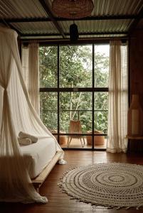 a bedroom with a bed and a large window at SPICE TRADER in Nusa Penida