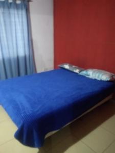 a bedroom with a blue bed with a blue bedspread at Moru in Mar del Tuyú