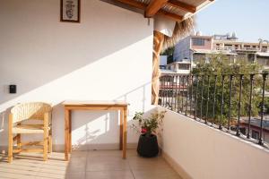 a balcony with a wooden table and a chair at The perch in Puerto Escondido