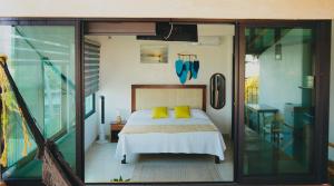 a bedroom with a bed with yellow pillows at The perch in Puerto Escondido