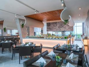 a restaurant with tables and chairs and a bar at Pullman Jakarta Central Park in Jakarta