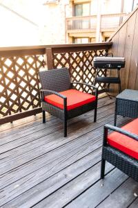 a chair with a red cushion sitting on a deck at The Huntsville Nest - 2BR Near SHSU - Pool - WiFi - Free Parking in Huntsville