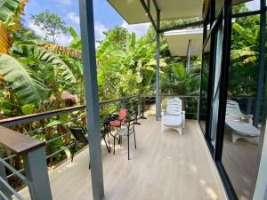 a balcony of a house with chairs and tables at Modern Bungalows in Ko Chang