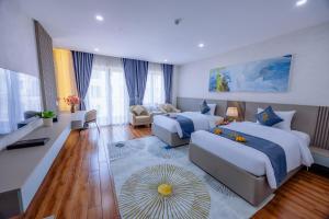 a bedroom with two beds and a living room at Cannes Ben Tre Hotel in Ben Tre
