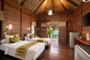 two beds in a room with wooden walls at Gecko Villa & Bungalows in Nusa Lembongan +20 photos