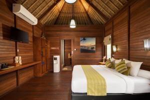 a bedroom with a large bed with wooden walls at Gecko Villa & Bungalows in Nusa Lembongan