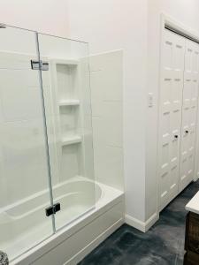 a glass shower in a bathroom with white cabinets at La remontee in LʼAnse-Saint-Jean +13 photos