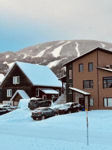 a snow covered parking lot in front of a building at La remontee in LʼAnse-Saint-Jean