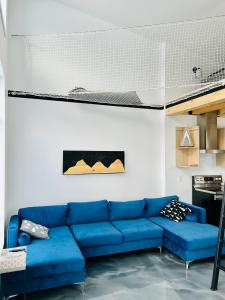 a living room with a blue couch in a room at La remontee in LʼAnse-Saint-Jean