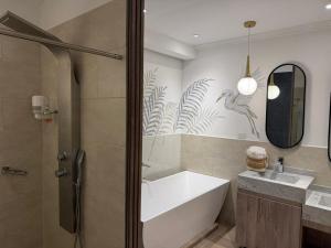 a bathroom with a bath tub and a sink at El Zócalo Hotel Boutique in Filandia