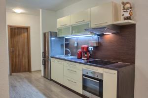 a kitchen with white cabinets and a red appliance at Apartman Chopok Juh Ema Superior in Tale
