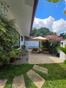 a patio with an umbrella and some plants at RVilla El Nido in El Nido