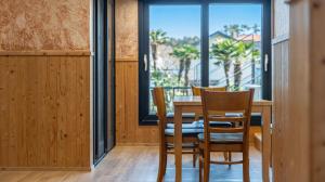 a dining room with a table and chairs and a window at Diorem Pension in Jeju