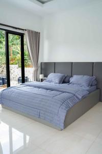 a bedroom with a large bed with blue sheets at Moment Villa in Lembang +57 photos
