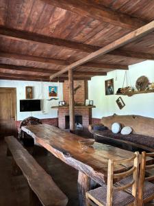 a living room with a wooden table and a fireplace at Gugoshvili's Cellar in Kvareli