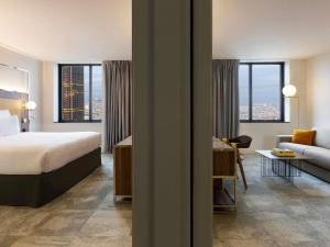 a hotel room with a bed and a couch at Pullman Paris Montparnasse in Paris