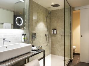 a bathroom with a sink and a shower at Pullman Paris Montparnasse in Paris